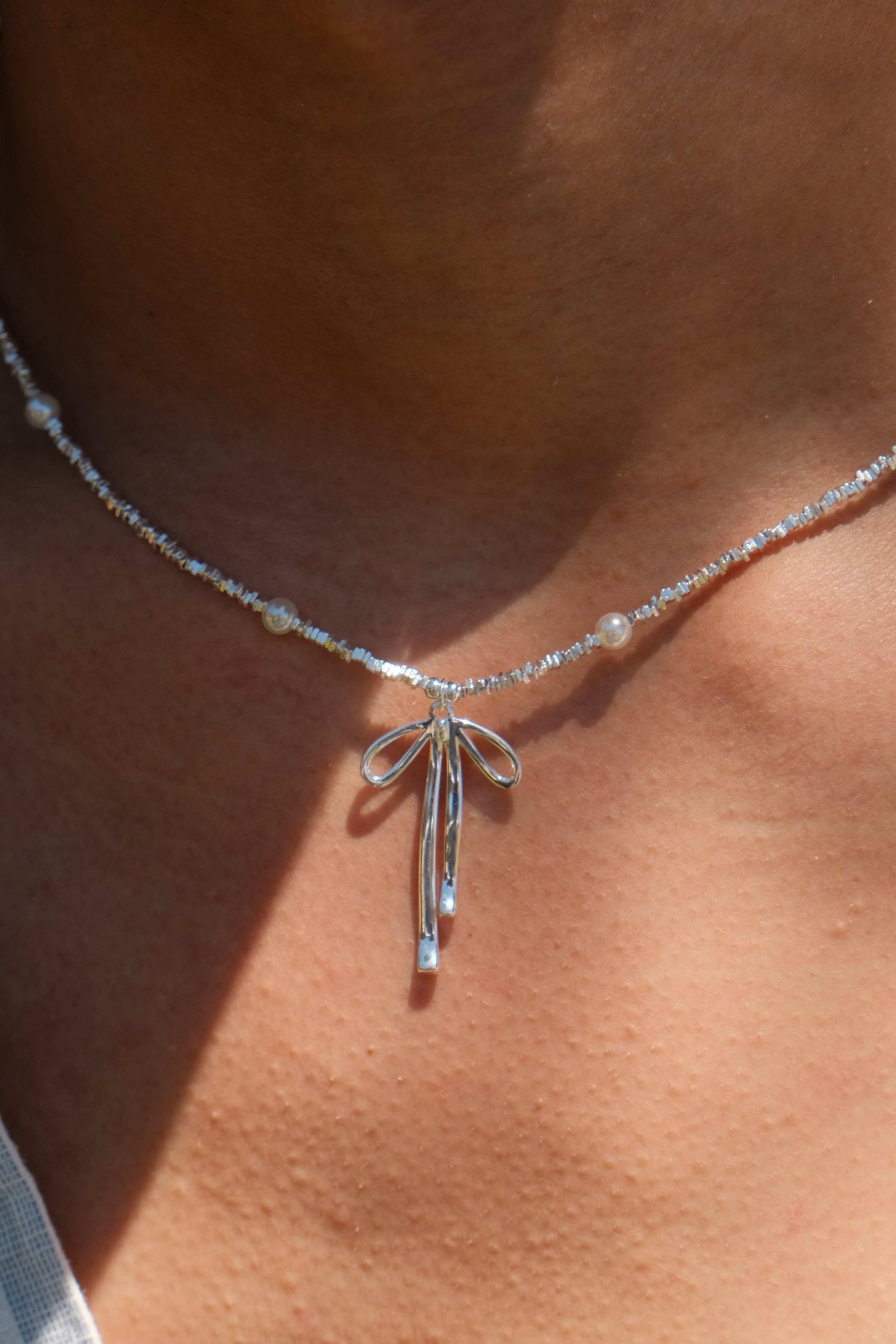 Threads of Becoming – Silver & Pearl Bow Necklace