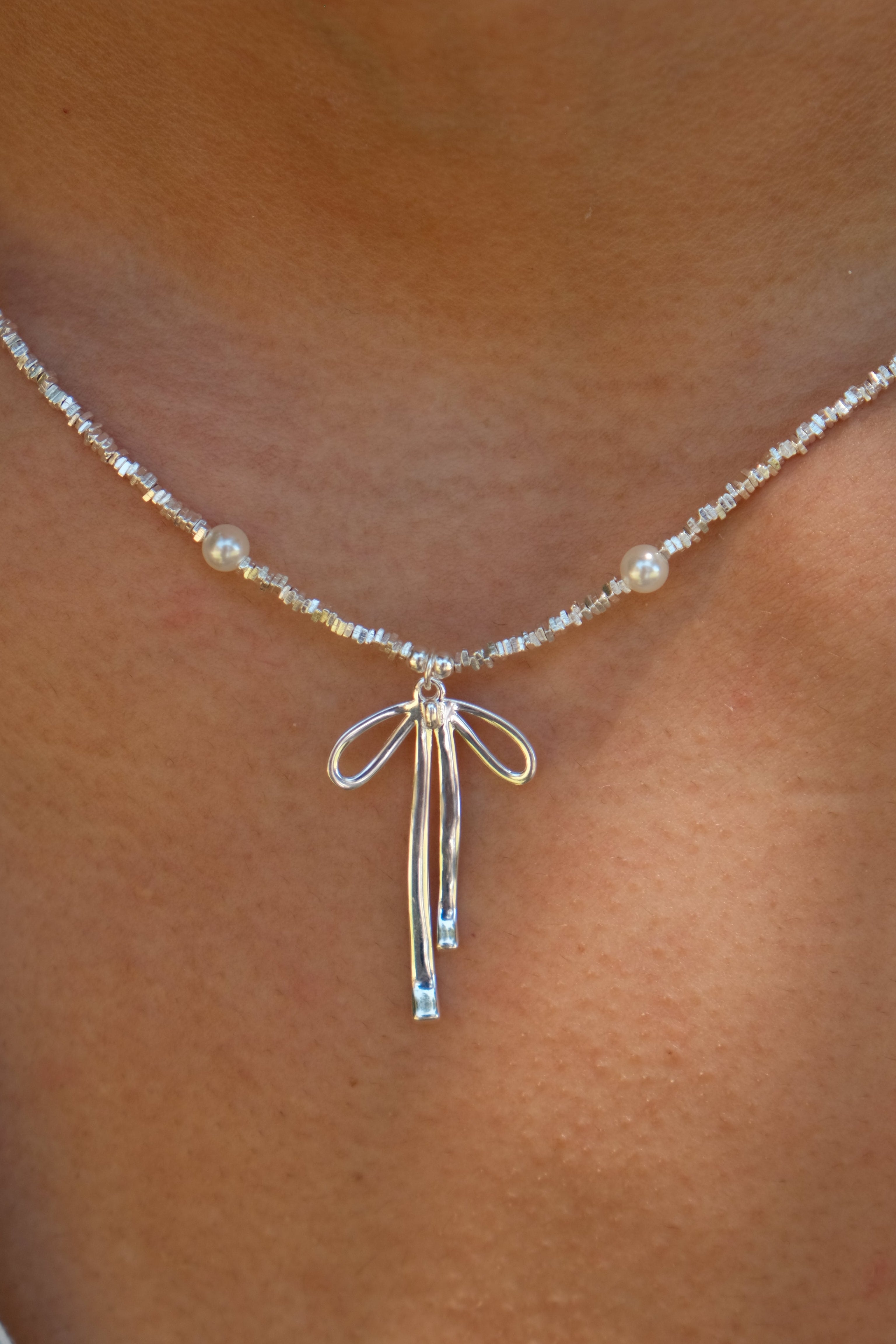 Silver necklace with a bow pendant